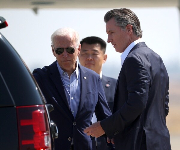 president joe biden stands next to a car speaking with gov. gavin newsom.