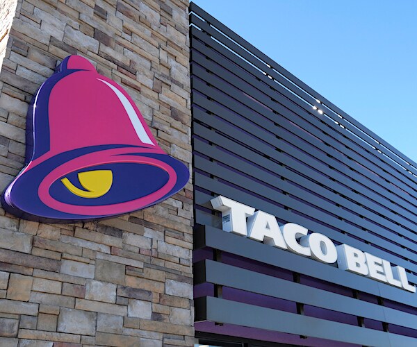 a sign for taco bell and its logo is shown on the side of a building