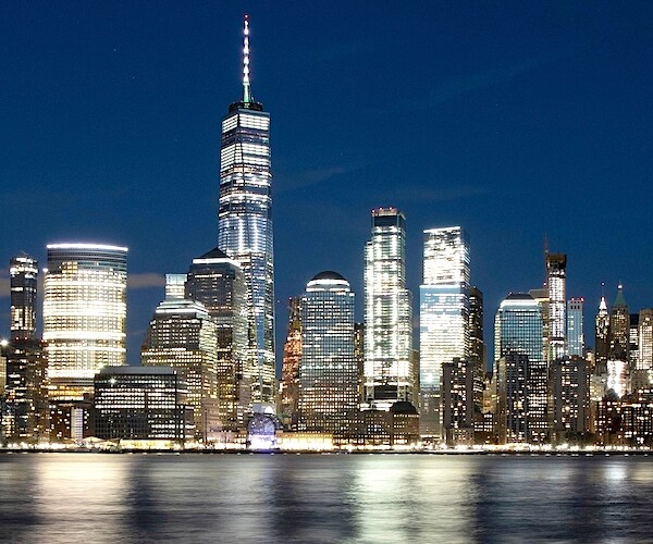 the well-lit skyline of New York City as seen from new jersey