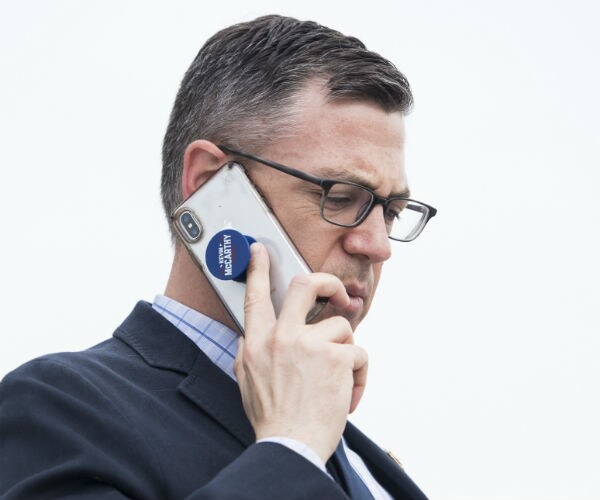 Rep. Jim Banks talks on a cell phone wiith a pop socket attached.