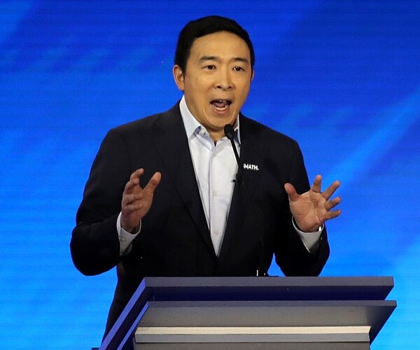 andrew yang speaks from behind podium