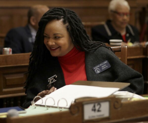 sen. nikema williams is seen on the georgia state senate floor in a dark jacket and red blouse
