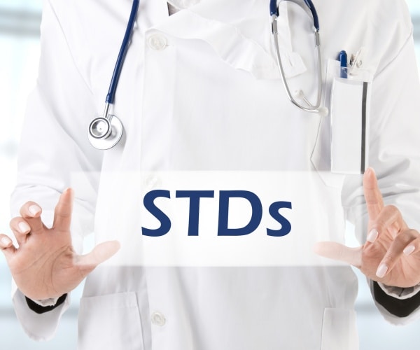 Doctor holding sign that says STDs