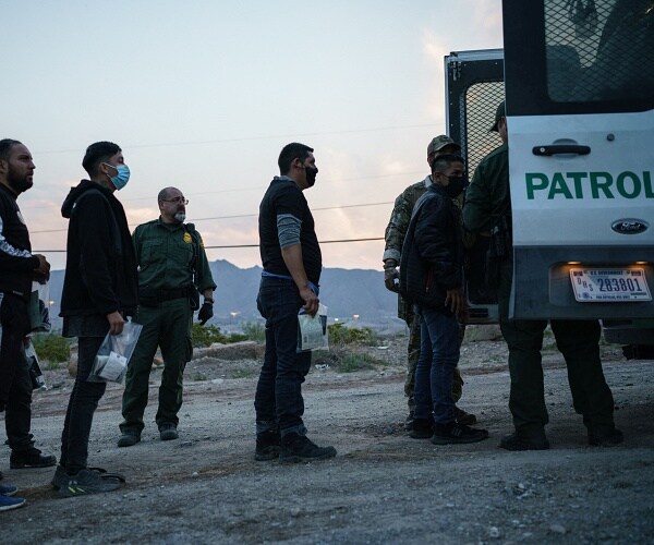 migrants line up to get in van