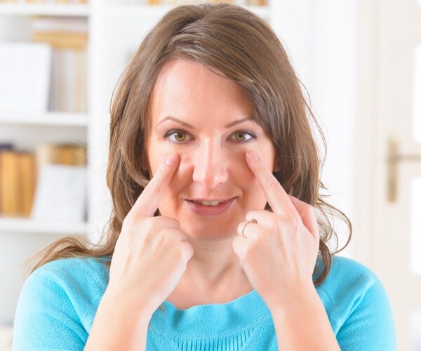 woman tapping around her eyes
