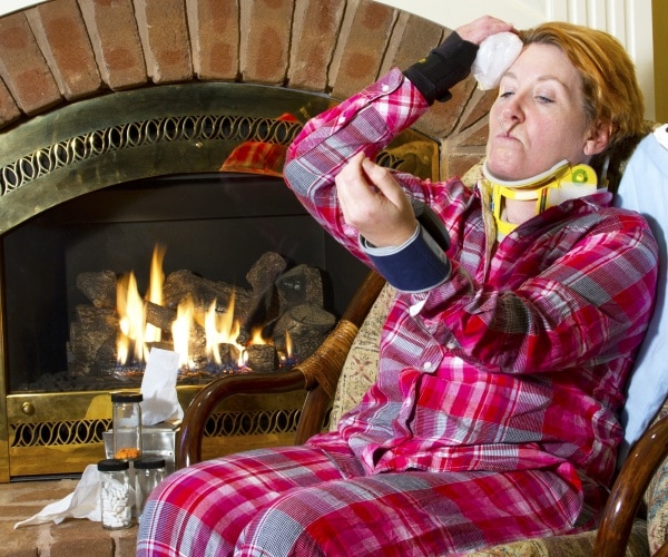 woman with excessive fear of illness taking temp, ice pack on head, neck brace