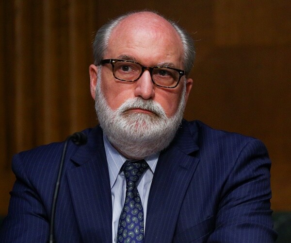 garrett grigsby sits behind table