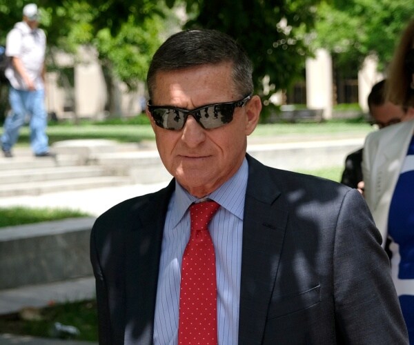flynn in a dark gray suit red tie and blue striped shirt