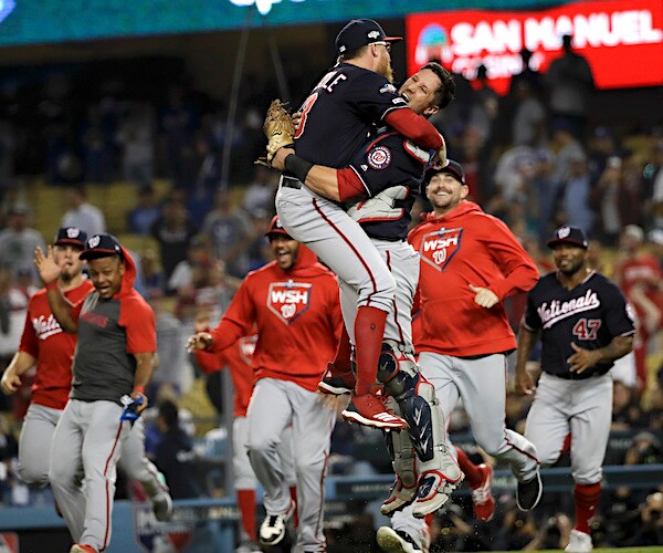 the washington nationals celebrate on the field at the end of their baseball playoffs series victory