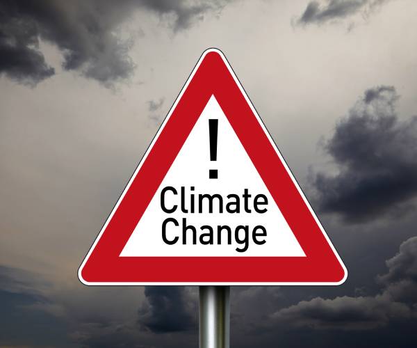 a road sign with climate change and and exclamation mark on it