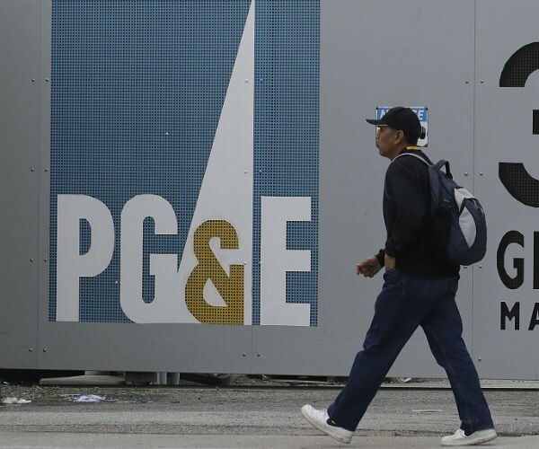 man walking past a pacific gas & electric co. entrance in daly city, calif.