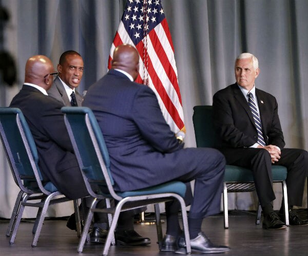 vice president mike pence is shown sitting and speaking with 3 black men