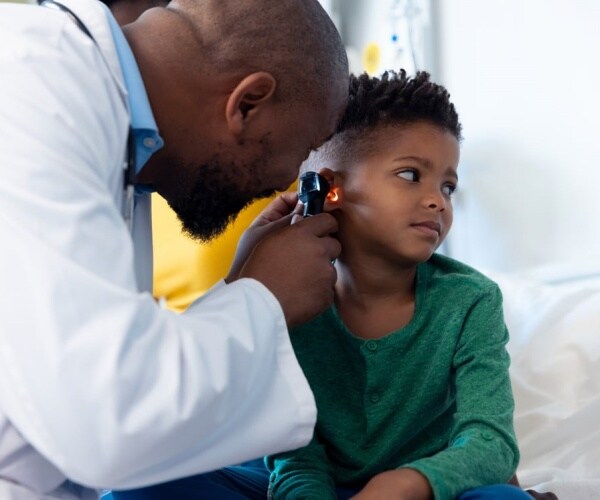 pediatrician looking in child's ear