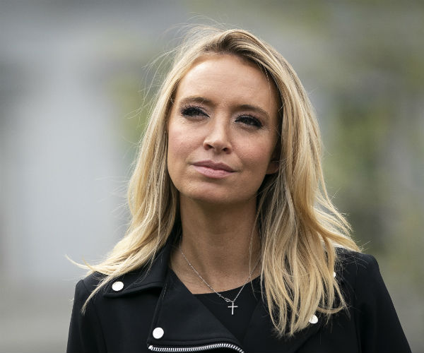 kayleigh mcenany is shown in a black dress with silver accents and a cross necklace on