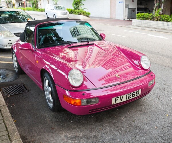 bright pink porsche in the road