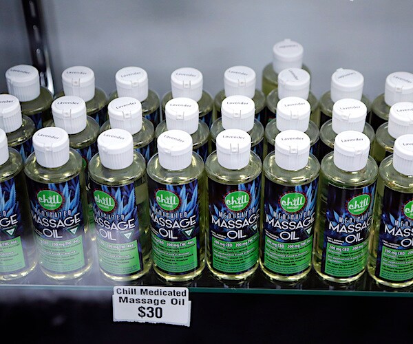 bottles of massage oil with cannabidiol and tetrahydrocannabinol are on a shelf for thirty dollars