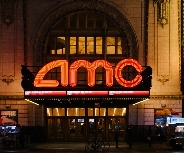 people stand outside amc theater