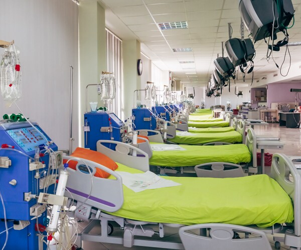 rows of hospital beds and kidney dialysis machines