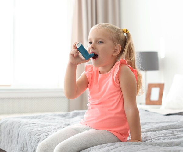 a girl using an asthma inhaler
