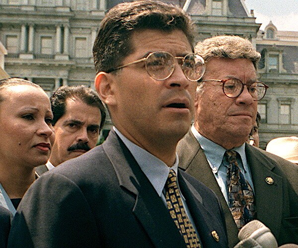 xavier becerra stands outdoors at a news conference