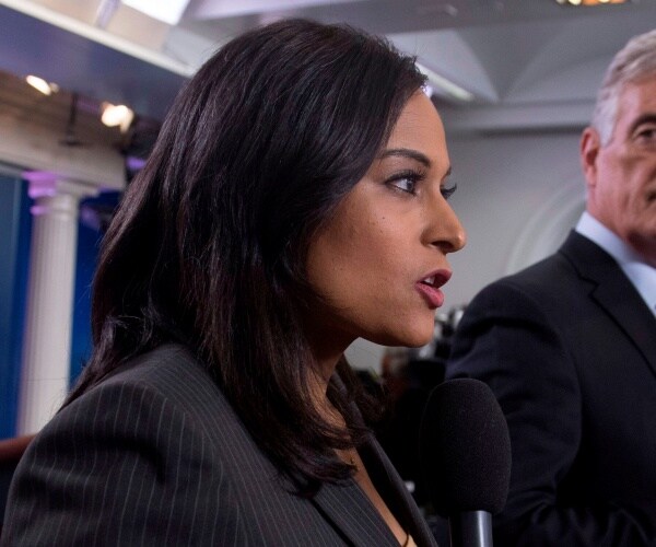 welker in a suit speaking into a mic in the press briefing room