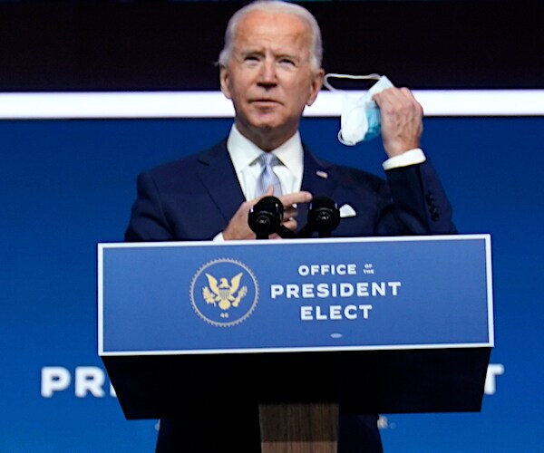 joe biden struggles to take off his face mask at his office of the president elect podium