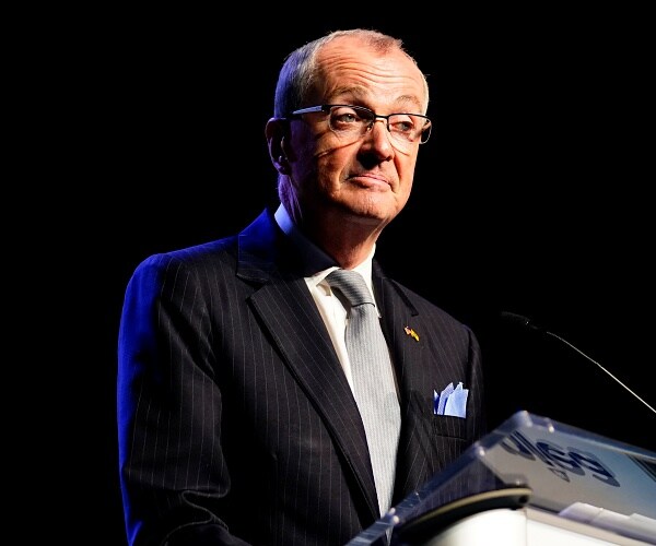 phil murphy stands behind podium