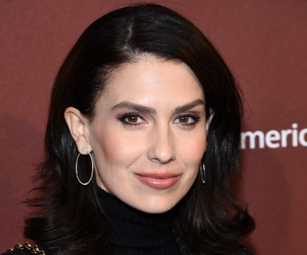 baldwin in a black turtleneck and silver hoop earrings