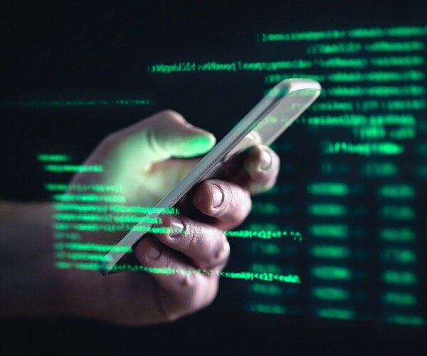 phone hacker image with coding text in green in the background