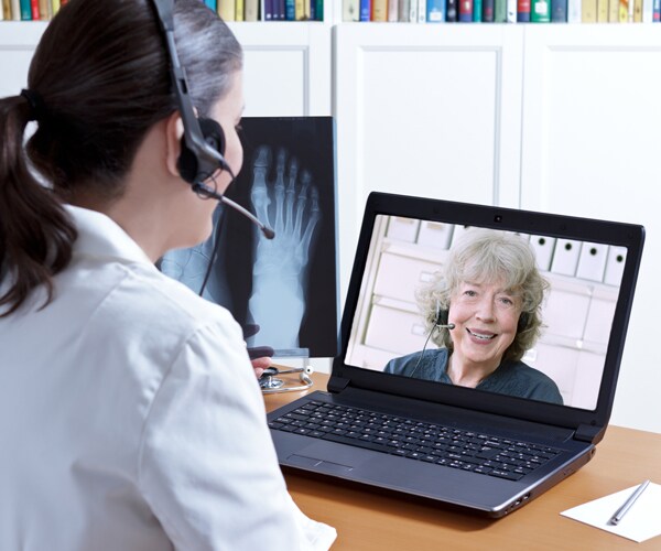 a doctor speaking with a patient over the computer