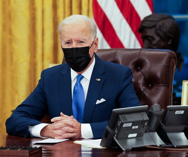 joe biden sits at resolute desk