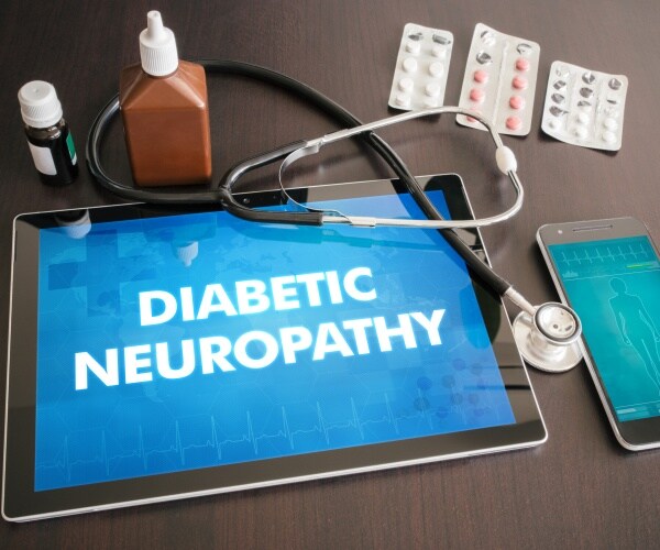 tablet with Diabetic Neuropathy on screen, stethoscope, pills