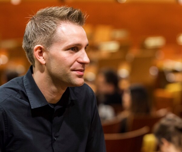 schrems in a black button down shirt