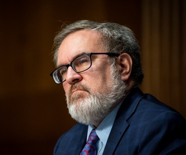 wheeler in a navy blue suit and purple tie