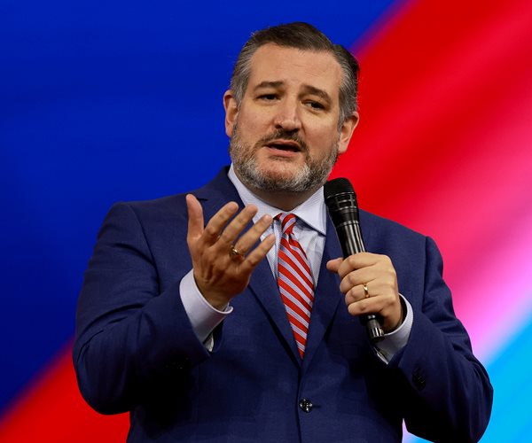 Ted Cruz gestures while speaking into a microphone