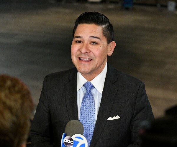 carranza in a black suit and blue tie speaking to an abc news reporter
