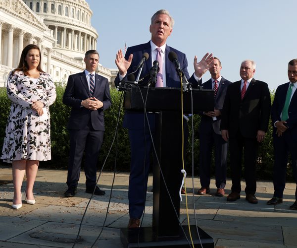 Kevin McCarthy speaks at a podium in front of house republicans