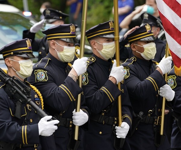 the police honor guard hold up flags in formal uniforms and masks