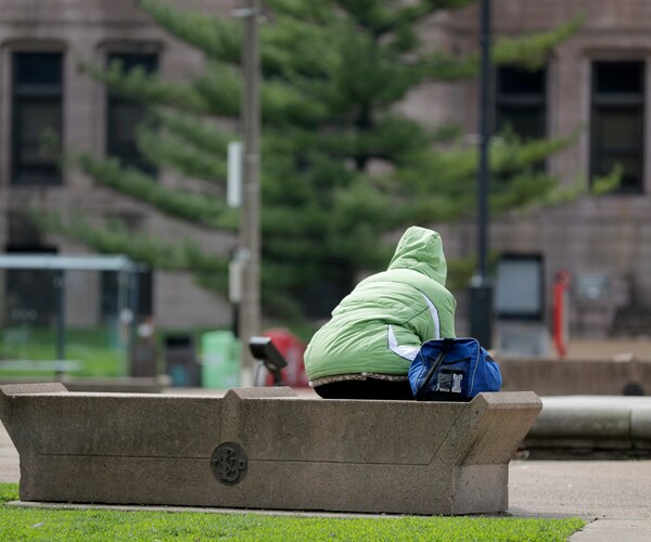 a person sits on a bench in st louis missouri