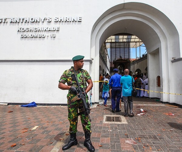 military man patrols exterior of sri lankan destroyed church on easter 2019