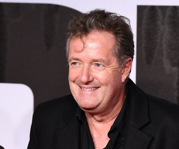 morgan in a black suit smiling