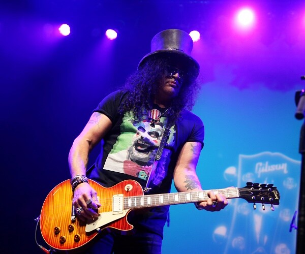 slash plays guitar onstage