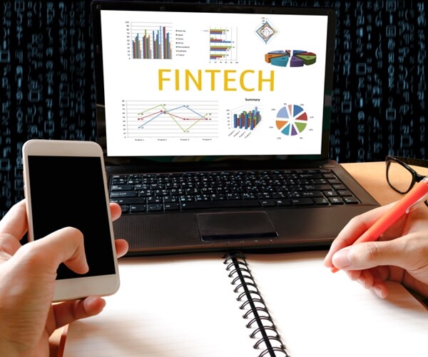 working and graph and business technology on laptop screen with fintech on screen