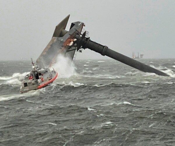 rescue boat heads towards capsized boat