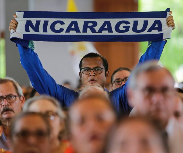 a man in a crowd holds a banner that reads nicaragua