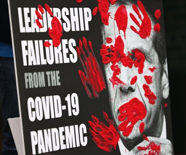 andrew cuomo book poster with red handprints 