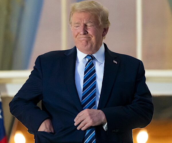 President Donald Trump removes his mask upon returning to the White House after his COVID-19 hospitalization