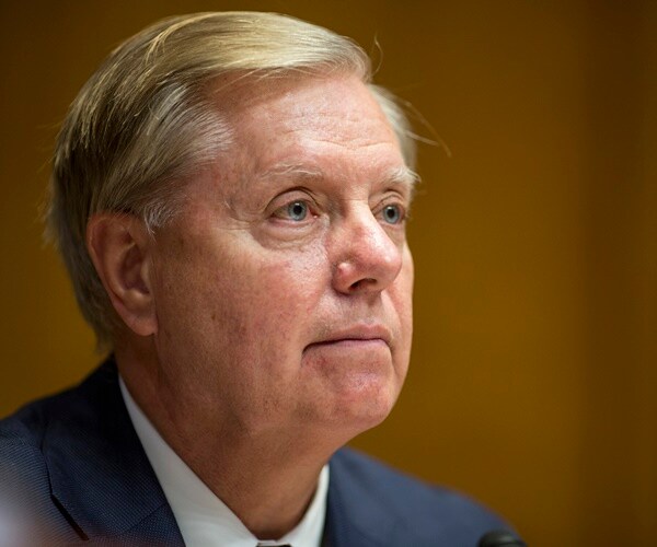 sen lindsey graham listens to someone speak
