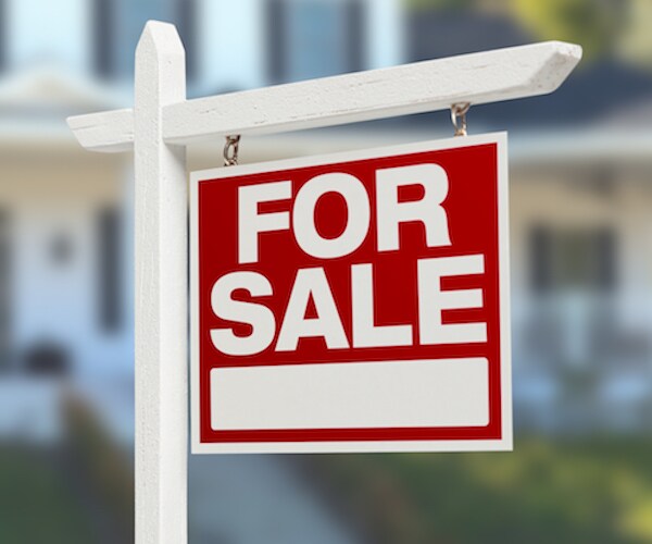 for sale sign in front of a house