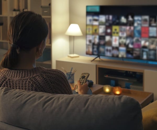 woman sitting on couch up late watching tv